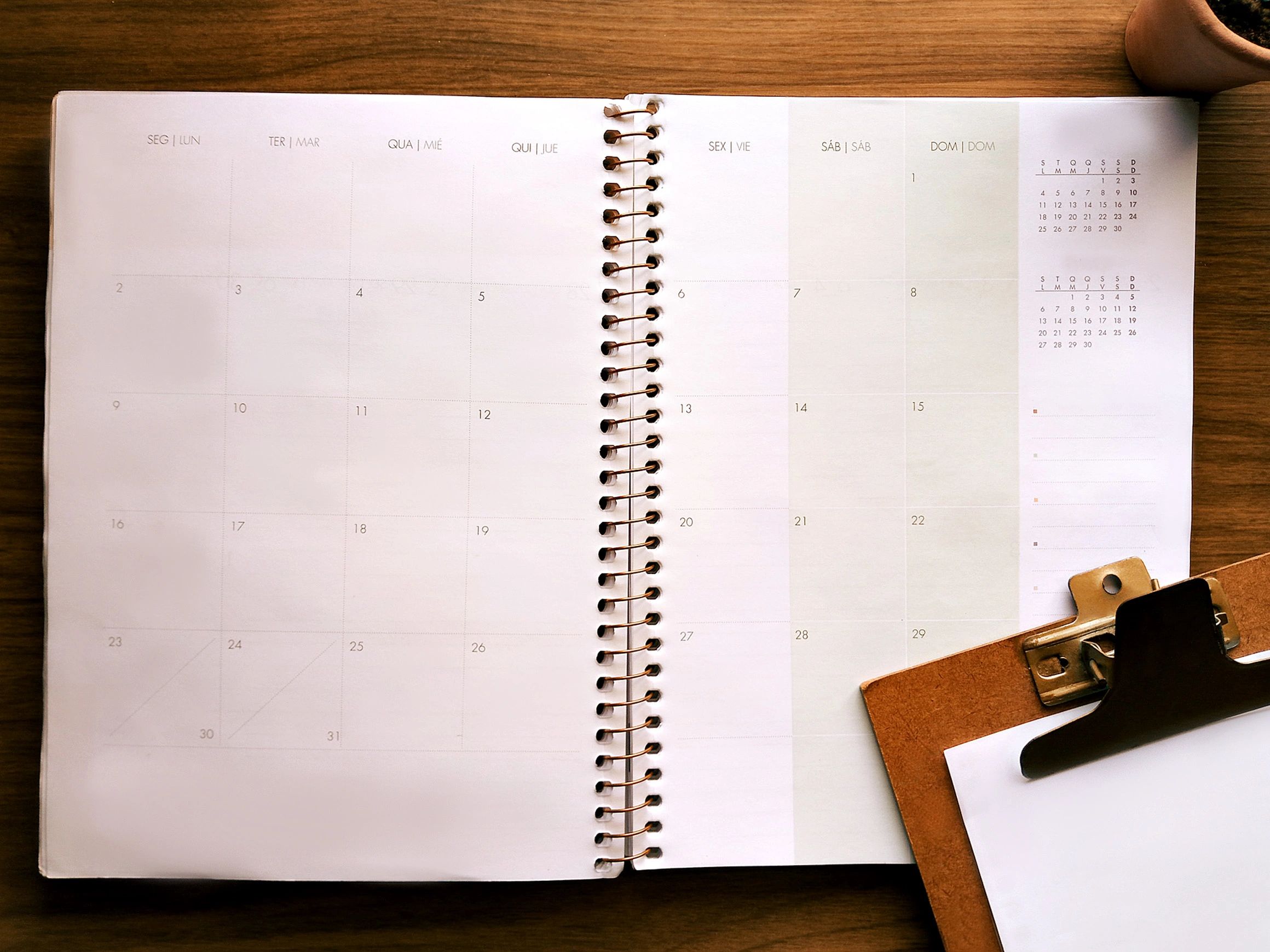 Styled planner workspace with clipboard, plant, and soft neutral desk accessories
