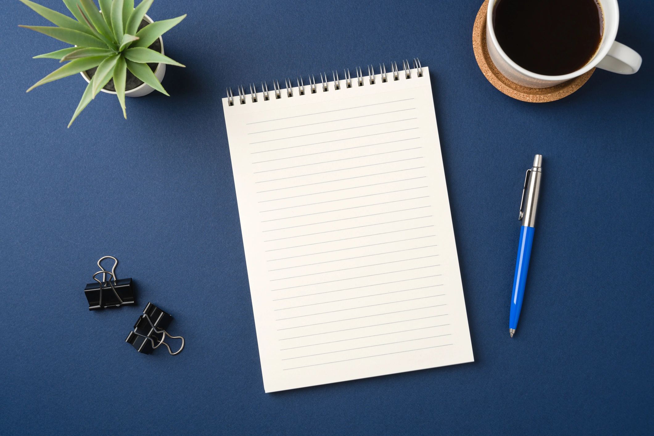 Top view of a calm planner workspace with notebook and coffee